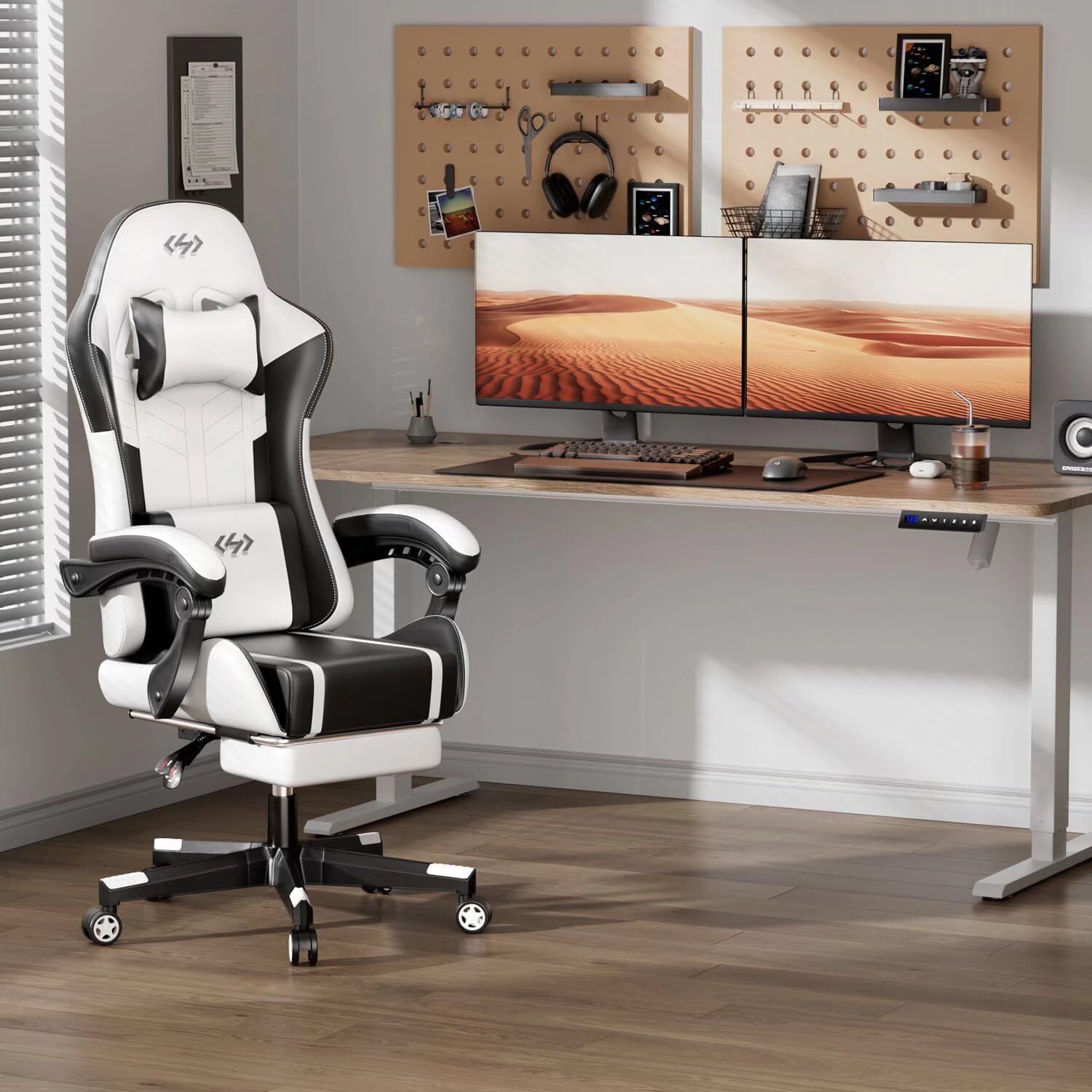 White and black gaming chair in a modern home office with dual monitor setup on wooden desk